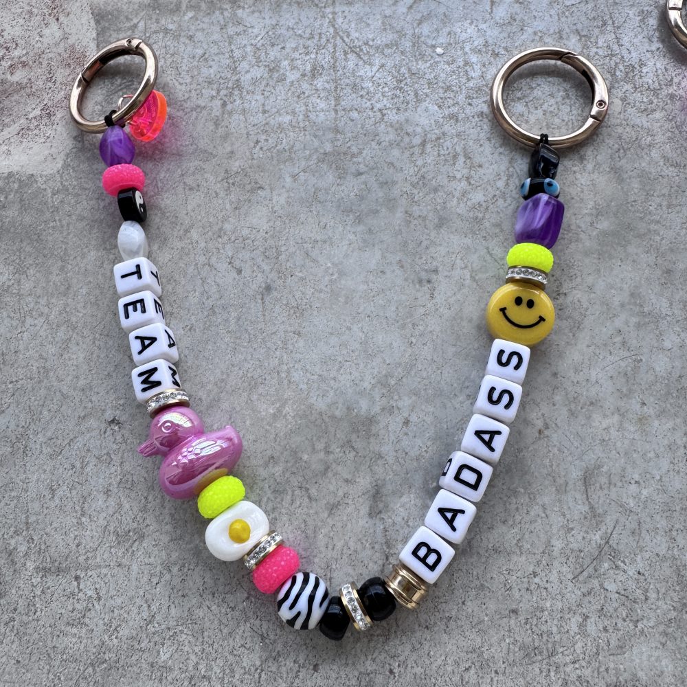 Bijou de sac Team Lovely Lunatic, perles smiley, canard, décalées et colorées, messages Badass, Cartel , Bankable.