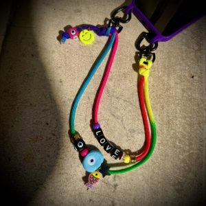 Bijou de sac ou téléphone Mayas Smiley Protector , cordon fluo message Love et oeil, Bella-pampa